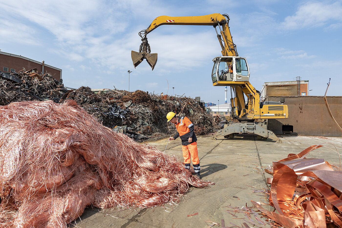 Foto: Aurubis: Bagger neben einem Kupferhaufen
